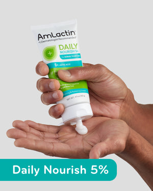 Pair of tanned hands squeezing AmLactin Daily Nourish 5% Cream Tube on Light Grey Background. Daily Nourish 5% Callout Flag in Teal on bottom of image.