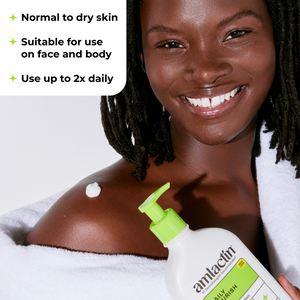 A smiling woman wrapped in a white towel holds a bottle of amlacin All Over Body Wash. The image includes text overlays stating 'Normal to dry skin', 'Suitable for use on face and body', and 'Use up to 2x daily'.