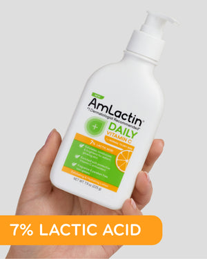 Female hands holding AmLactin Daily Vitamin C 7% Lotion 7.9 oz Pump Top Bottle. 7% Lactic Acid callout flag in orange at bottom left of image.